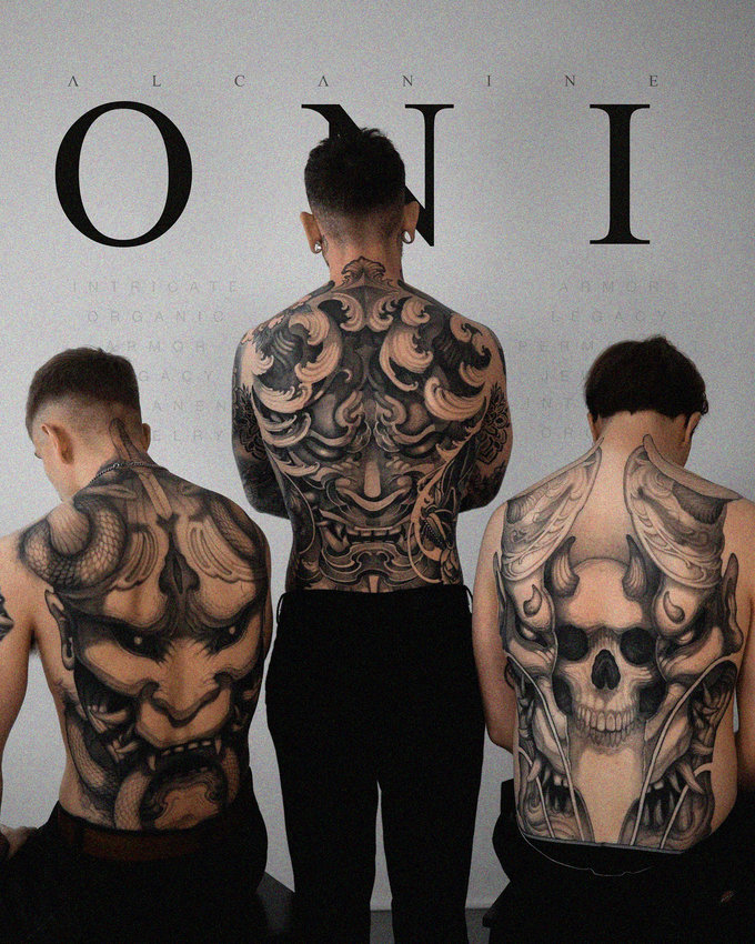 Tattooed Trio Underneath Towering Text