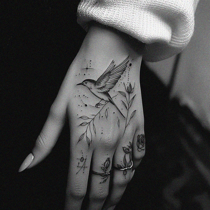 Shadowed Hummingbird Tattoo Held in Hand