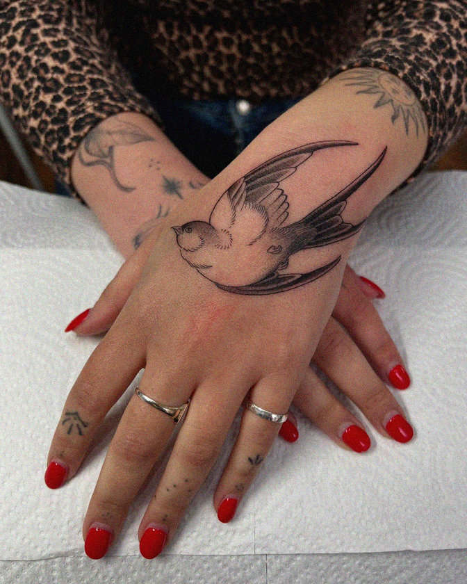 Bird Tattoo Amid Subtle Ink and Scarlet